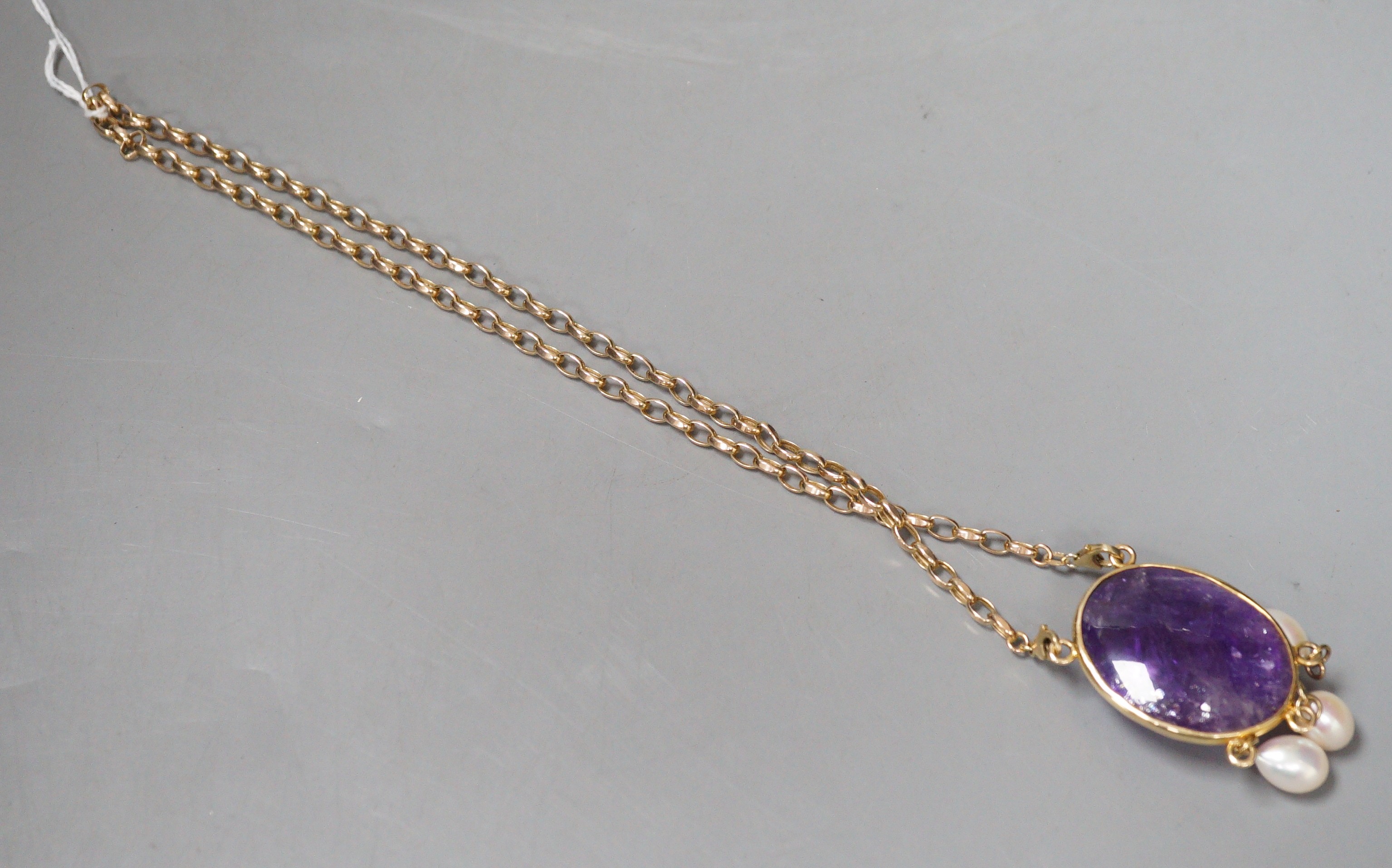 A modern 375 yellow metal mounted cabochon amethyst and three stone culture pearl set drop pendant, 58mm, on a 375 chain, 46cm, gross weight 37.8 grams.